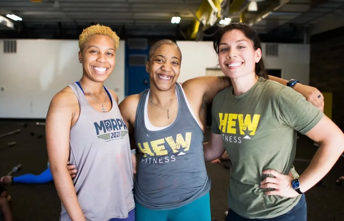 Three HEW members smiling together after class